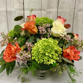 Mixed bouquet of roses and green hydrangeas in a glass vase