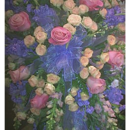 Large pink and peach rose spray with purple flowers and a blue ribbon