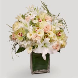 Bouquet of white and blush flowers in a square glass vase