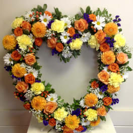 Heart-shaped floral wreath with orange, yellow, white, and purple flowers