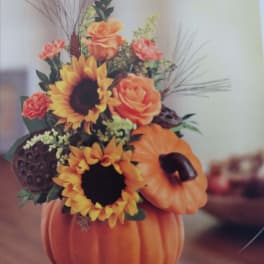 Pumpkin-shaped floral arrangement with sunflowers and orange roses