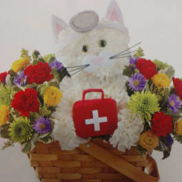 White cat plush in a flower basket with a red first-aid kit