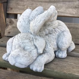 Stone rabbit sculpture on a wooden bench