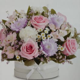Pink and lavender bouquet in a white hat box