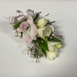 Small corsage of pale pink orchid and white blooms with ribbon and crystal accents