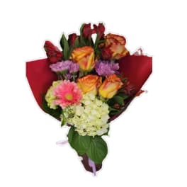 Mixed bouquet of roses, gerbera daisies, and hydrangeas wrapped in red paper