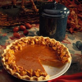 Pumpkin pie on a plate with a slice removed