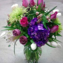 Bouquet of pink, purple, and white flowers in a glass vase