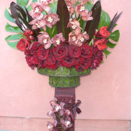 Tall standing floral arrangement with red roses and pink orchids