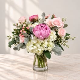 Pink and white floral arrangement in a clear glass vase