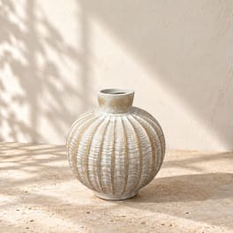 Textured round ceramic vase on a stone surface