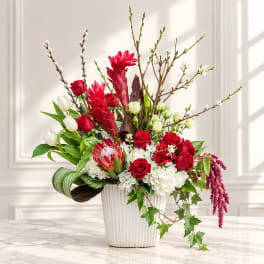 Red roses and white tulips in a white vase with tall branches