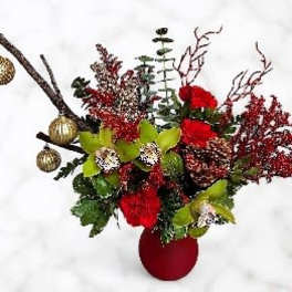 Red floral arrangement in a red vase with gold ornaments and branches