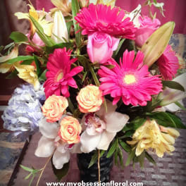 Mixed bouquet with pink gerbera daisies, roses, lilies, and orchids