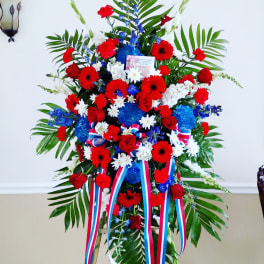 Large standing floral spray with red, white, and blue flowers