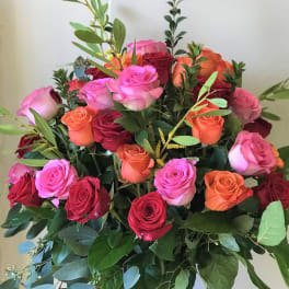 Bouquet of pink, red, and orange roses in a glass vase