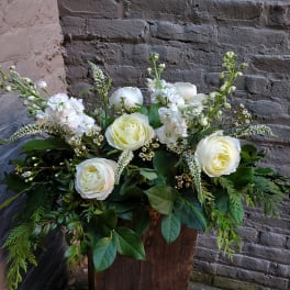 White roses and white blooms in a rustic wooden container