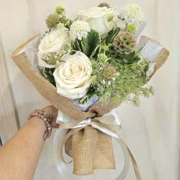 White rose bouquet wrapped in burlap with a satin ribbon