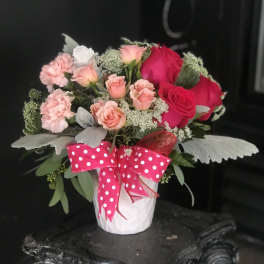 Pink and red rose bouquet in a white pot with a polka-dot ribbon