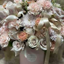 Blush and ivory bouquet of roses, carnations, and mums in a pink hatbox