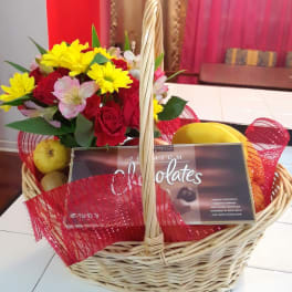 Basket of mixed flowers with chocolates and fruit