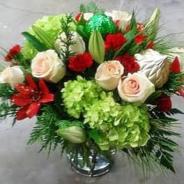 Bouquet of white roses, red flowers, and green hydrangeas in a vase