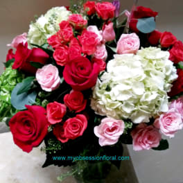 Bouquet of red, pink, and white roses with hydrangeas