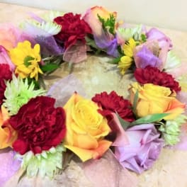 Colorful floral wreath with roses and carnations on a light surface