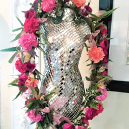 Pink and coral floral garland wrapped around a mirrored mannequin form