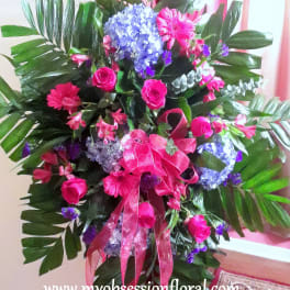 Large pink and blue floral standing arrangement with ribbon