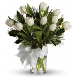 Arrangement of white tulips in a clear glass vase with a white ribbon bow.