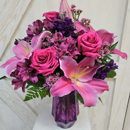Pink and purple bouquet with roses and lilies in a purple vase