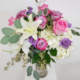 Bouquet of pink and white roses with lilies in a glass vase