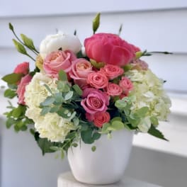 Pink and white floral arrangement in a white vase