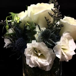 White roses and pale blooms in a clear glass vase