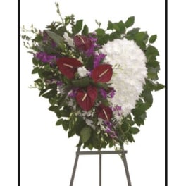Heart-shaped funeral spray with white and burgundy flowers on an easel
