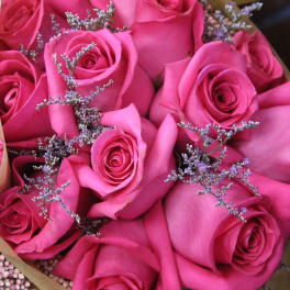 Bouquet of bright pink roses with small purple filler flowers