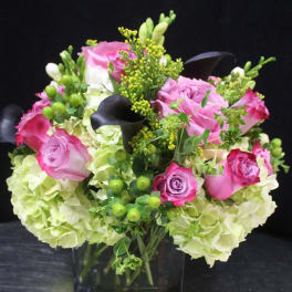 Pink roses and pale hydrangeas in a square glass vase