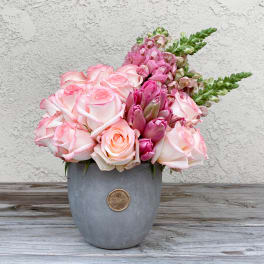 Pink roses and snapdragons arranged in a gray vase