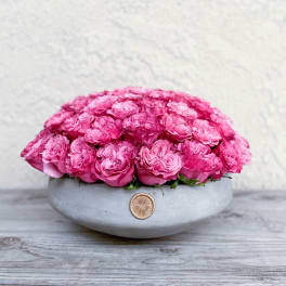 Pink roses arranged in a low gray bowl vase