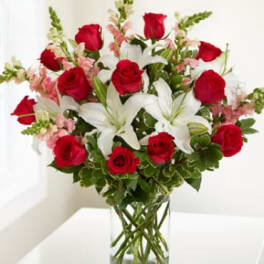Bouquet of red roses and white lilies in a clear glass vase