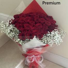 Bouquet of red roses with white baby's breath wrapped in red and clear paper