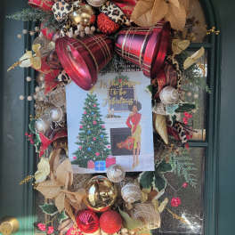 Decorated holiday wreath on a green door with ribbons and ornaments