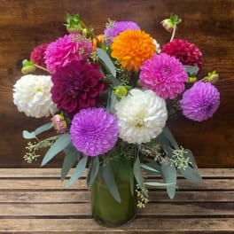 Bouquet of colorful dahlias in a green glass vase