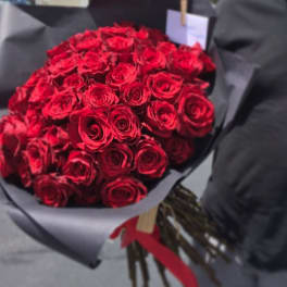 Bouquet of red roses wrapped in black paper with a red ribbon