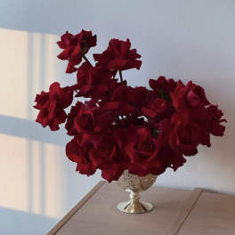 Red roses arranged in a decorative silver vase
