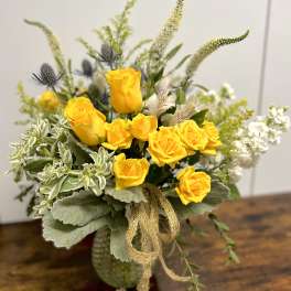 Yellow roses in a vase with white and green accents