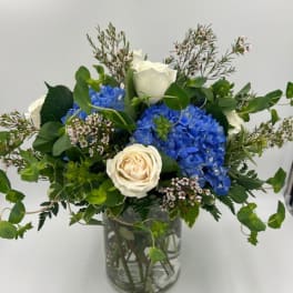Blue hydrangeas and white roses in a glass vase