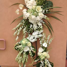 Tall white floral standing arrangement on a metal easel