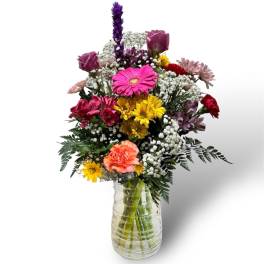 Mixed bouquet of colorful flowers in a clear glass vase